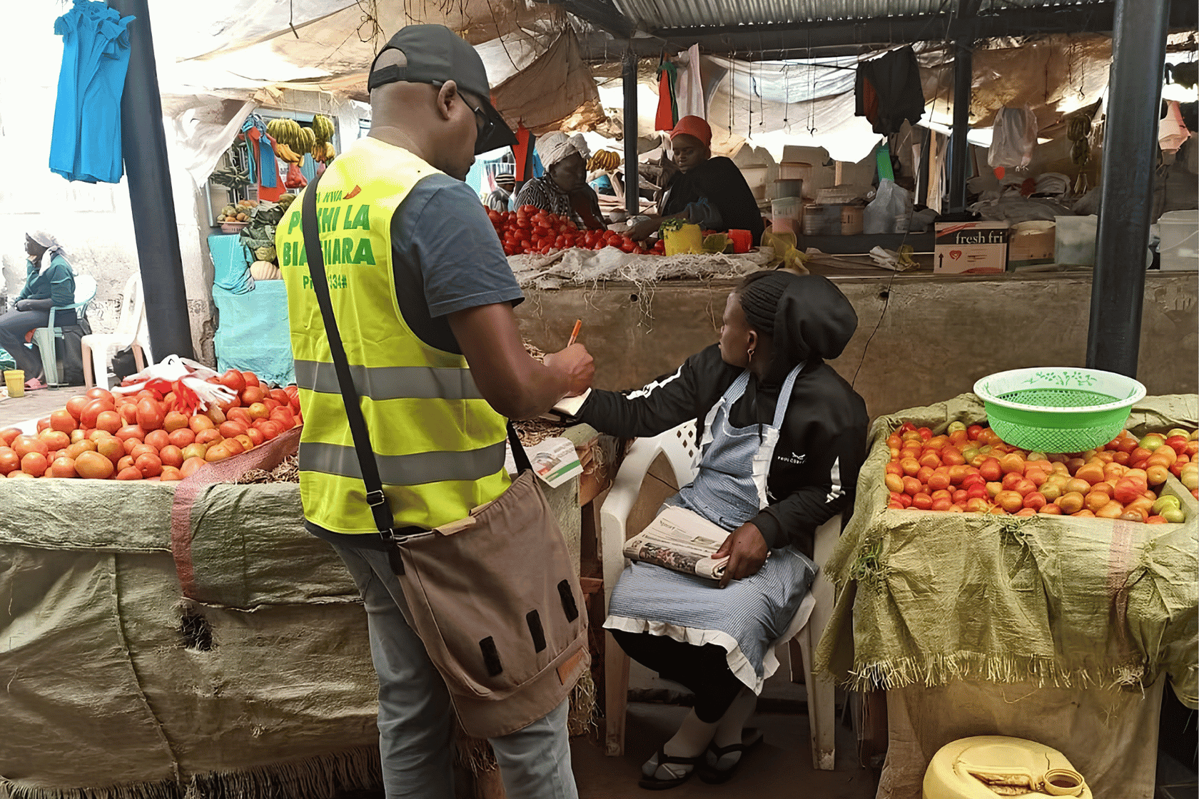 A YUX Researcher engaging with a woman micro-entrepreneur at her market stall.